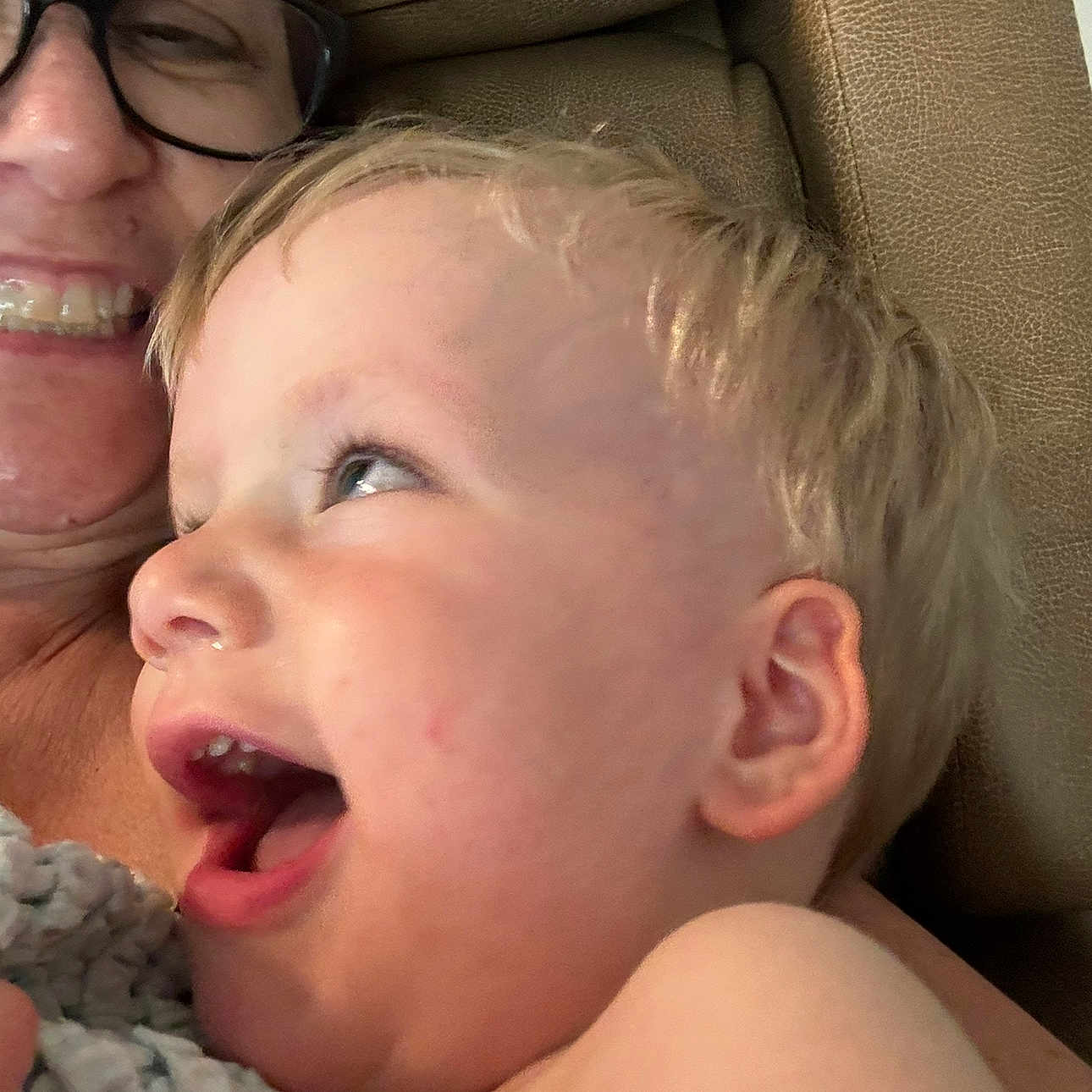 William is registered to the contest to win money with this photo: accessories, baby, bodypart, cosmetics, couch, cushion, face, furniture, glasses, happy, head, homedecor, laughing, mouth, newborn, person, photography, portrait, smile, teeth