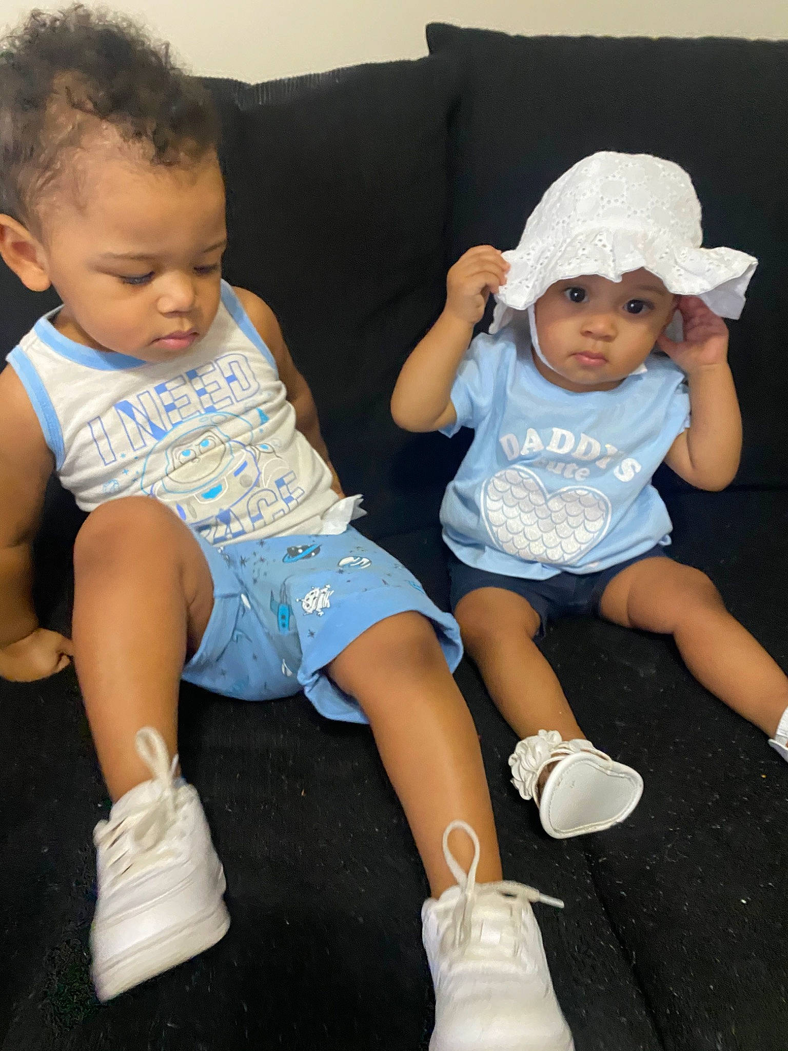 Esco is registered to the contest to win money with this photo: arm, baby, baby_toddler_clothing, child, comfort, costume_accessory, couch, hand, headwear, human_body, human_leg, knee, lap, leg, person, product, shoe, shorts, sitting, sock