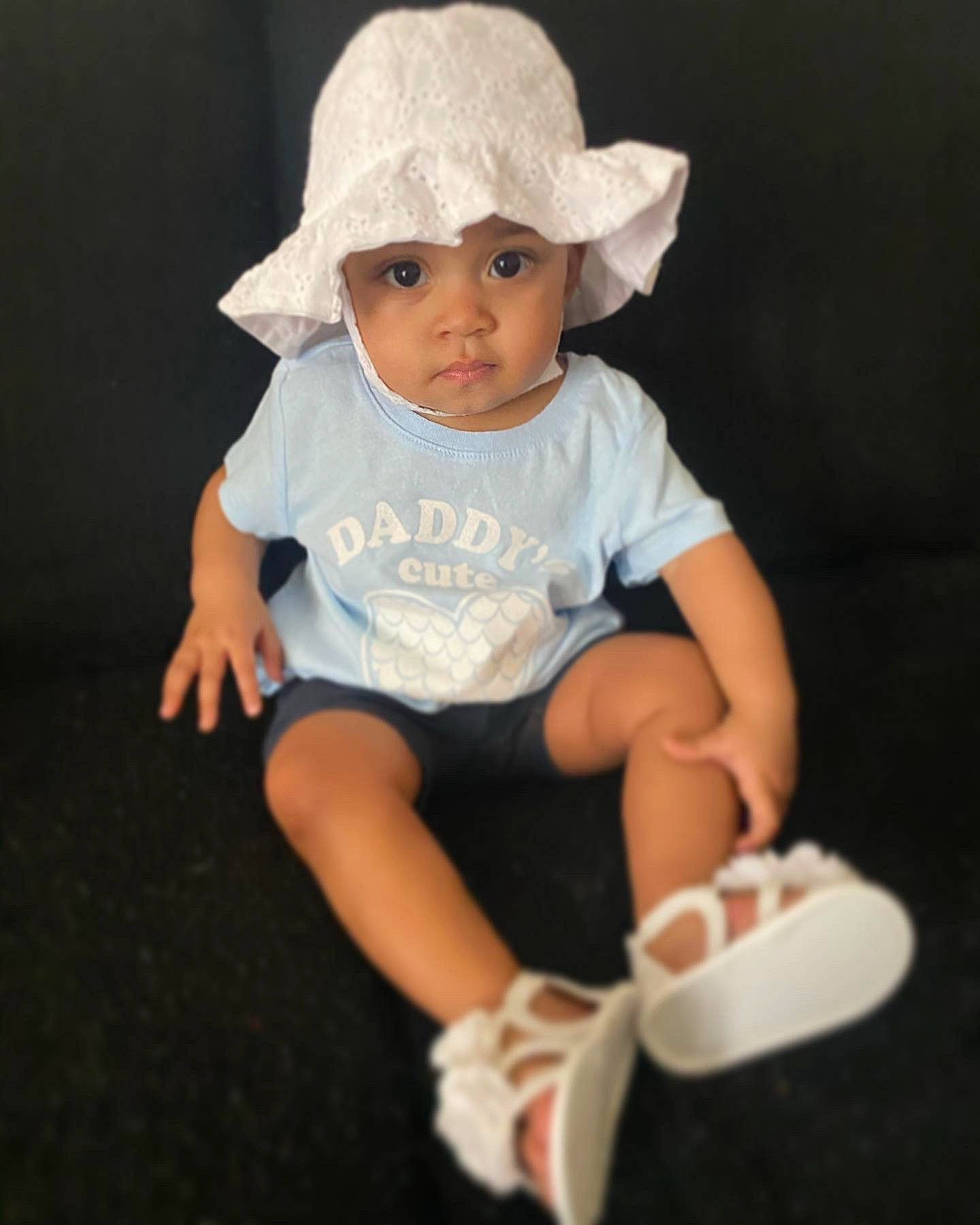 Amira is registered to the contest to win money with this photo: ankle, baby, baby_products, baby_toddler_clothing, bonnet, button, cheek, child, child_model, costume_accessory, costume_hat, foot, hand, headwear, person, product, shoe, skin, sock, sun_hat