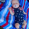 baby, infant, sleeping, pacifier, striped_blanket, outdoor, grass, sock, clothing, stars, red, white, blue, person, cute, peaceful, resting, child, summer, nap