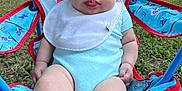 Zurriah joined the competition — help win amazing prizes! baby, child, outdoor, grass, chair, onesie, bib, tongue, playful, cute, person, infant, summer, seat, legs, sock, parked_cars, daylight, expression, cute_face