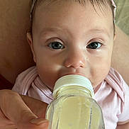 Zurriah joined the competition — help win amazing prizes! baby, bottle, feeding, hand, headband, pink_clothing, close_up, infant, cute, eyes, face, skin, nourishment, person, child, portrait, young, human, indoors, tender_moment