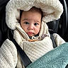 baby, child, infant, car_seat, blanket, coat, hood, face, wide_eyes, curious, pensive, straps, safety, soft_texture, warm_clothing, indoor, portrait, close_up, cute, bundle