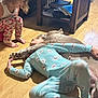 Haven is registered to the contest to win money with this photo: child, dog, floor, pajamas, curly_hair, indoor, wooden_floor, furniture, paw, holding_hands, crouching, patterned_clothing, relaxing, pet, comfort, friendship, playful, home, casual, cozy