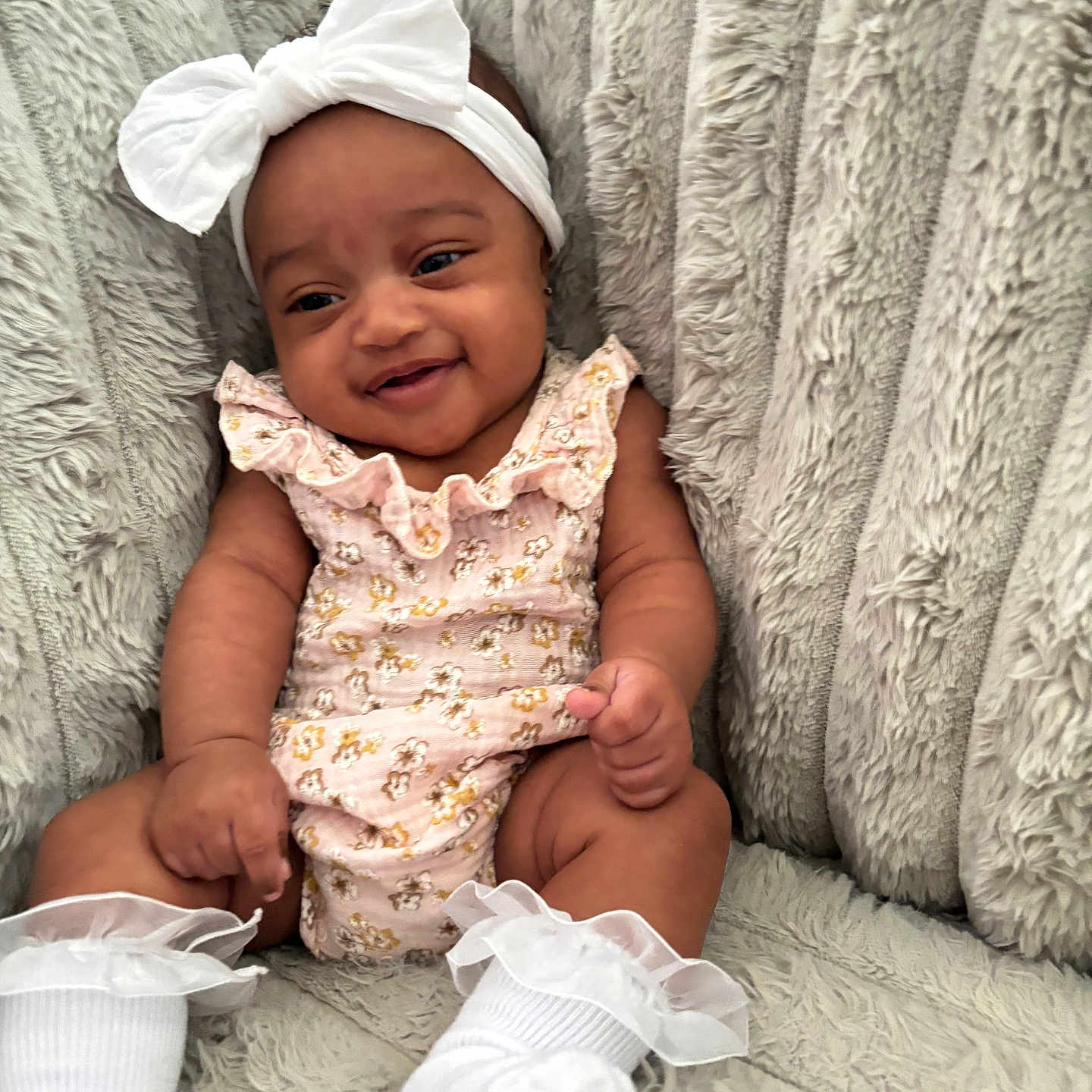 Jersei is registered to the contest to win money with this photo: baby, blanket, bow, child, clothing, cozy, cute, floral, happy, headband, indoors, infant, pink, portrait, sitting, smile, socks, soft, texture, white