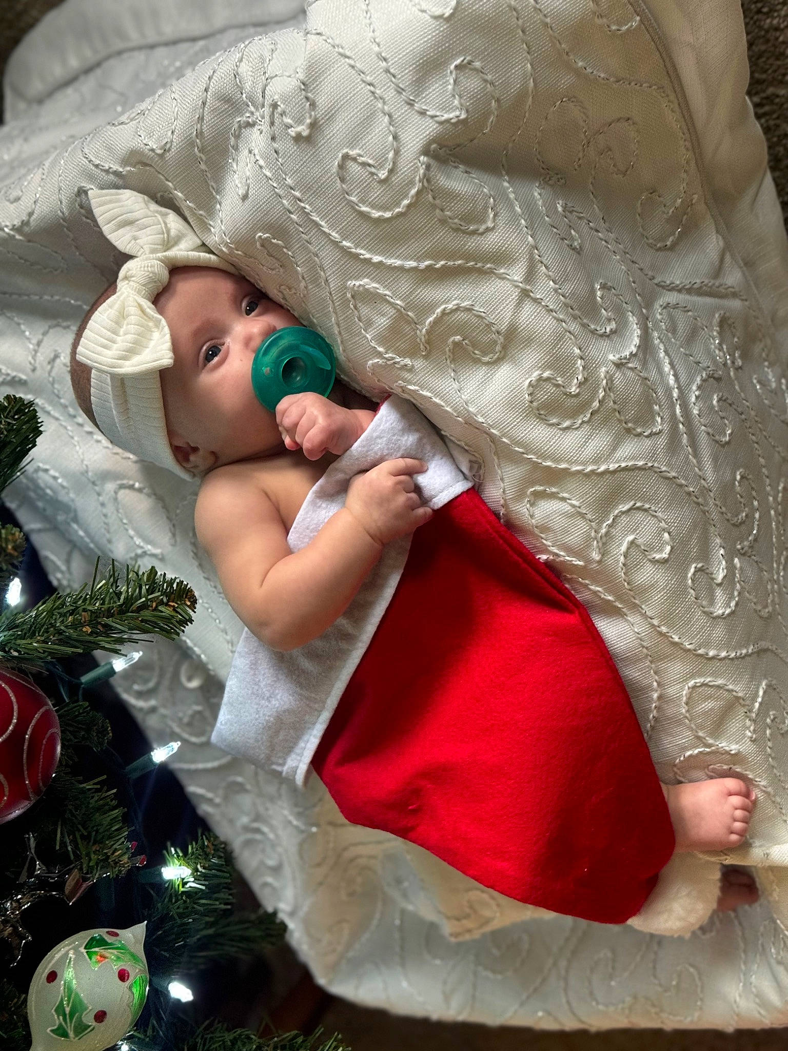 Allison is registered to the contest to win money with this photo: baby, bridal_accessory, child, christmas_tree, comfort, embellishment, event, fashion_accessory, fictional_character, flash_photography, happy, hat, headpiece, headwear, holiday, linens, person, petal, pink, room