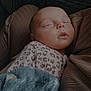 Athena is registered to the contest to win money with this photo: baby, sleeping, blanket, blue, star_pattern, face, infant, cozy, soft, clothing, texture, brown, closeup, peaceful, portrait, child, indoors, rest, cuddle, comfort
