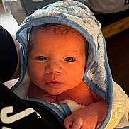 Jensen is registered to the contest to win money with this photo: newborn, baby, towel, blue, white, face, hand, person, skin, indoor, portrait, clothing, holding, infant, cute, looking, wrapped, soft, warm, closeup