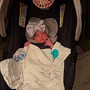Lakelyn joined the competition — help win amazing prizes! newborn, baby, infant, sleeping, car_seat, blanket, bow, headband, pacifier, portable_fan, parent_hand, indoor, portrait, face, eyes_closed, bundled, clothing, safety_straps, wood_floor, cozy