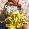 baby, bed, blanket, cozy, face, family_photo, hands, indoor, infant, legs, lying_down, newborn, portrait, rainbow, shirt, shorts, sleepy, unicorn, yawning, yellow_clothing
