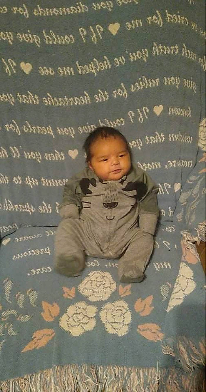 Joaquin is registered to the contest to win money with this photo: baby, baby_toddler_clothing, beauty, child, comfort, facial_expression, flooring, font, gesture, happy, military_camouflage, pattern, person, photo_caption, room, sitting, sleeve, smile, toddler, wood