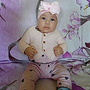 Seyda Melody is registered to the contest to win money with this photo: baby, blanket, bow, child, cozy, cute, expression, face, feet, floral_pattern, hands, headband, heart_pattern, indoor, infant, person, pink_clothing, portrait, sitting, socks