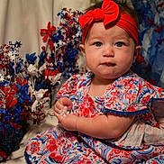 Emily is registered to the contest to win money with this photo: baby, child, infant, red_headband, floral_dress, blue, red, white, stars, decorations, patriotic, celebration, portrait, cute, sitting, face, hands, indoor, festive, holiday