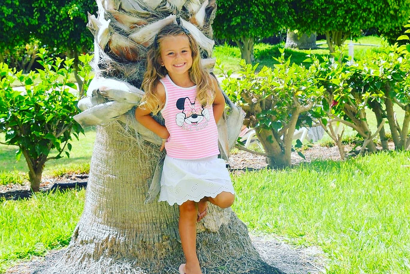 Emma participe au concours pour gagner de l'argent avec cette photo : botany, facial_expression, fawn, grass, groundcover, hair, hairstyle, happy, joy, leisure, people_in_nature, person, plant, shorts, shrub, smile, street_fashion, summer, sunlight, tree