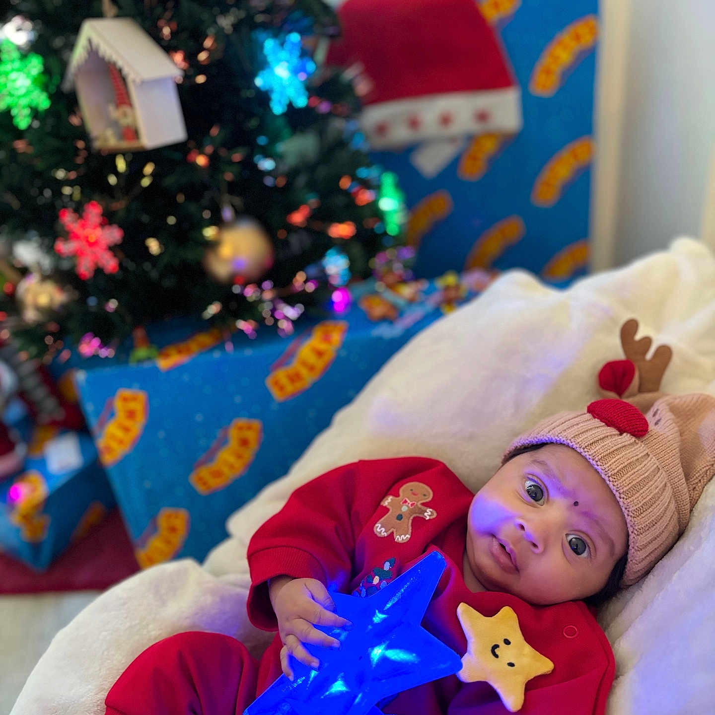 Ohena a rejoint le concours — aidez-le/la à gagner de superbes lots ! baby, blanket, child, christmas, christmas_tree, cozy, cute, decorations, festive, gift, glowing_toy, holiday, holiday_lighting, indoor, ornament, present, red_clothing, reindeer_hat, smiling_star, star_wand