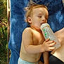 Izao a rejoint le concours — aidez-le/la à gagner de superbes lots ! toddler, baby, bottle, diaper, towel, outdoor, grass, sunlight, shade, relaxed, child, skin, hand, arm, person, nature, summer, resting, baby_bottle, young_child