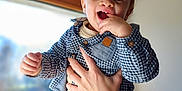 Izao participe au concours pour gagner de l'argent avec cette photo : baby, child, smiling, hand, window, indoor, portrait, blue_shirt, checkered, happy, person, young_child, cute, face, fingers, clothing, holding, light, background, casual