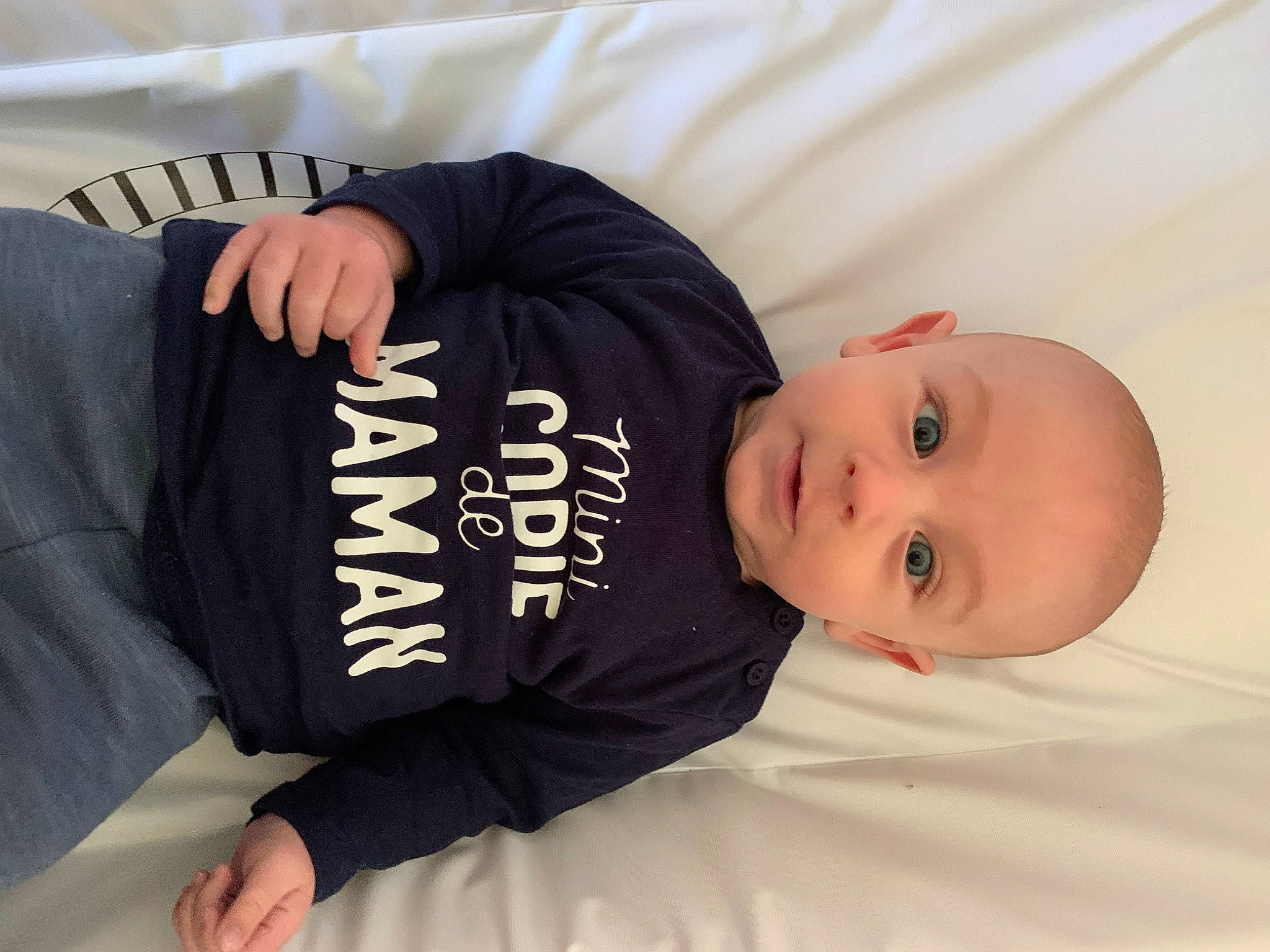 Lyzio participe au concours pour gagner de l'argent avec cette photo : arm, baby, baby_toddler_clothing, child, comfort, elbow, finger, font, foot, knee, linens, mammal, person, product, sitting, sleeve, t_shirt, thigh, thumb, toddler
