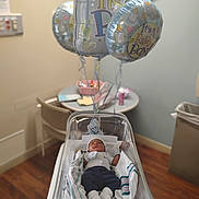 Mei'Leontah is registered to the contest to win money with this photo: baby, newborn, hospital, bassinet, balloons, baby_boy, blanket, maternity, nursery, resting, infant, hospital_room, medical, clothing, sleeping, crib, flooring, chair, table, trash_can