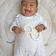 Amélia participe au concours pour gagner de l'argent avec cette photo : baby, smiling, infant, toy, giraffe, teether, cushion, blanket, white_clothing, onesie, happy, lying_down, cute, child, portrait, playful, indoors, soft_lighting, baby_girl, baby_boy