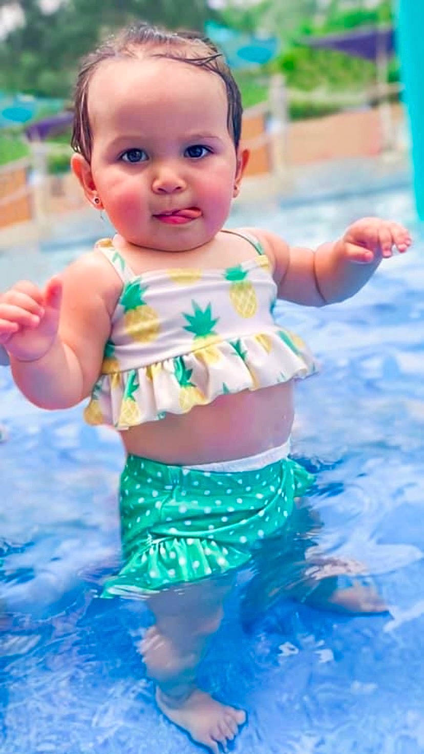 Gwendolyn is registered to the contest to win money with this photo: abdomen, aqua, baby, baby_toddler_clothing, cheek, child, child_model, day_dress, gesture, people_in_nature, person, pink, skin, summer, toddler, trunk, waist