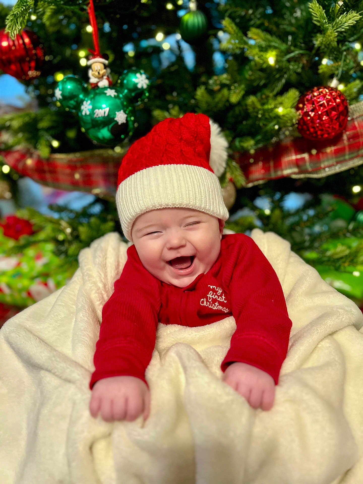 John joined the competition — help win amazing prizes! baby, child, christmas, holiday, festive, smiling, happy, red_hat, blanket, christmas_tree, ornaments, decorations, santa_hat, holiday_clothing, infant, celebration, joyful, seasonal, indoors, cute
