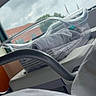 baby, infant, newborn, bassinet, hospital, hospital_room, blanket, swaddled, medical_equipment, window, sky, clouds, outdoor_view, vehicle_like_bassinet, gray_blanket, clear_plastic, nursery, resting, sleeping, photograph