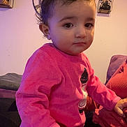 Valentina a rejoint le concours — aidez-le/la à gagner de superbes lots ! toddler, child, indoor, pink_clothing, curly_hair, face, person, furniture, clock, shelf, decor, hand, expression, seated, casual, portrait, warm_lighting, cute, young, cozy