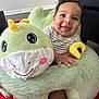 Lucas joined the competition — help win amazing prizes! baby, child, smiling, plush_toy, dinosaur, green, indoor, red_rug, striped_clothing, cute, happy, person, sitting, toy, soft, playful, infant, face, hand, home