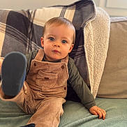 Côme a rejoint le concours — aidez-le/la à gagner de superbes lots ! toddler, child, overalls, corduroy, green_shirt, blue_eyes, plaid_blanket, couch, cushion, indoor, window, soft_fabric, footwear, curious_expression, sitting, hand, leg, cozy, portrait, young_child