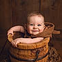 Côme a rejoint le concours — aidez-le/la à gagner de superbes lots ! baby, child, smile, blue_eyes, wooden_bucket, blanket, arm, face, portrait, cute, infant, wood_background, cozy, rustic, texture, hands, happy, sitting, indoors, warm_lighting