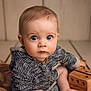 baby, child, blue_eyes, knitted_sweater, wooden_toy, curious, portrait, indoor, soft_lighting, floor, cuteness, close_up, infant, sitting, cozy, warm_colors, face, young_child, expression, toy