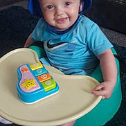 Tommy Rhys is registered to the contest to win money with this photo: baby, blue_hat, blue_shirt, nike_logo, baby_seat, toy_piano, smiling, indoor, child, playtime, sock, carpet, plastic_tray, happy, cute, face, infant, sitting, young_child, person