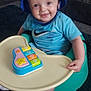 baby, blue_hat, blue_shirt, nike_logo, baby_seat, toy_piano, smiling, indoor, child, playtime, sock, carpet, plastic_tray, happy, cute, face, infant, sitting, young_child, person