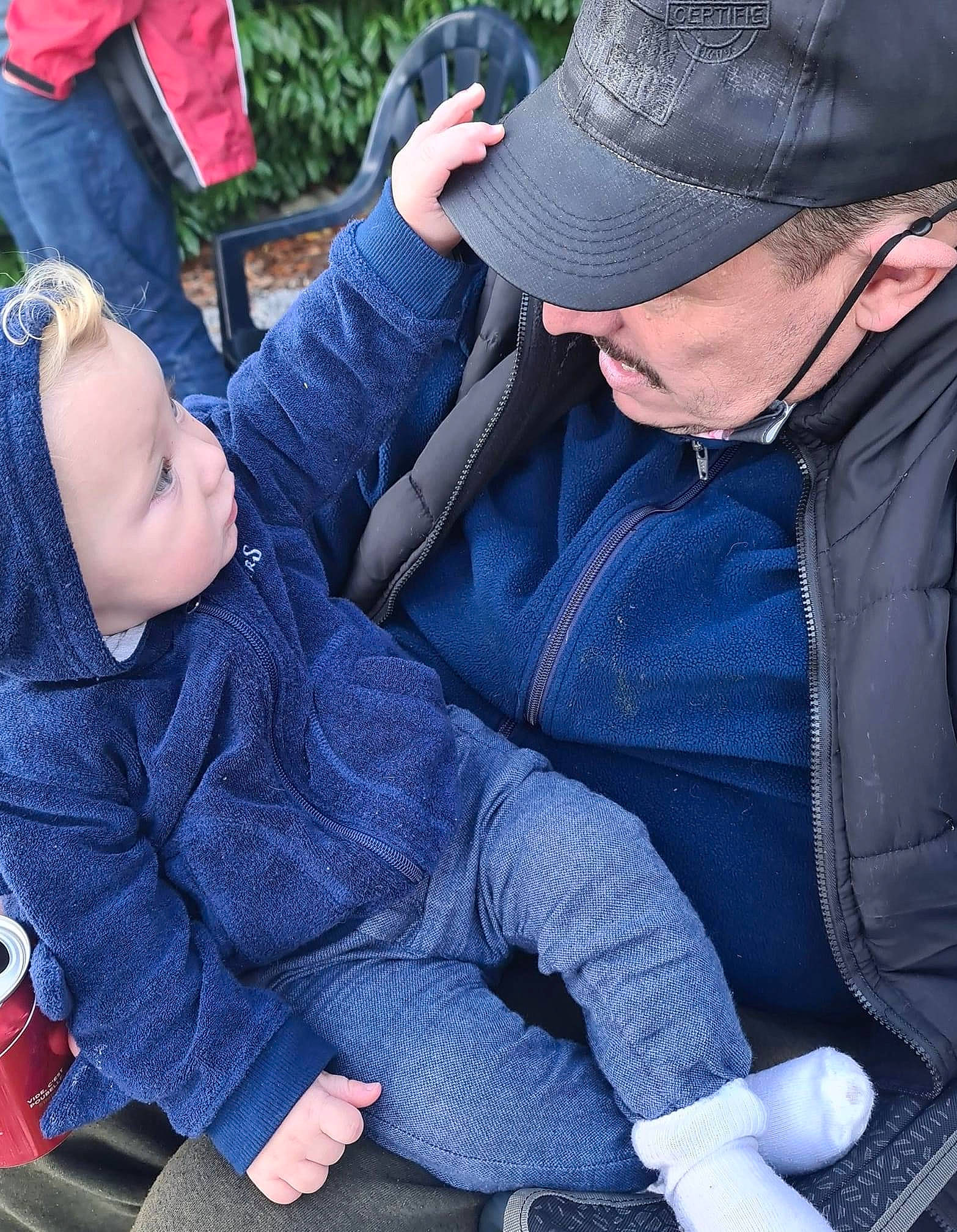 émilien participe au concours pour gagner de l'argent avec cette photo : baby, baby_products, baby_toddler_clothing, comfort, costume_accessory, costume_hat, fedora, human, interaction, jacket, lap, love, person, sun_hat