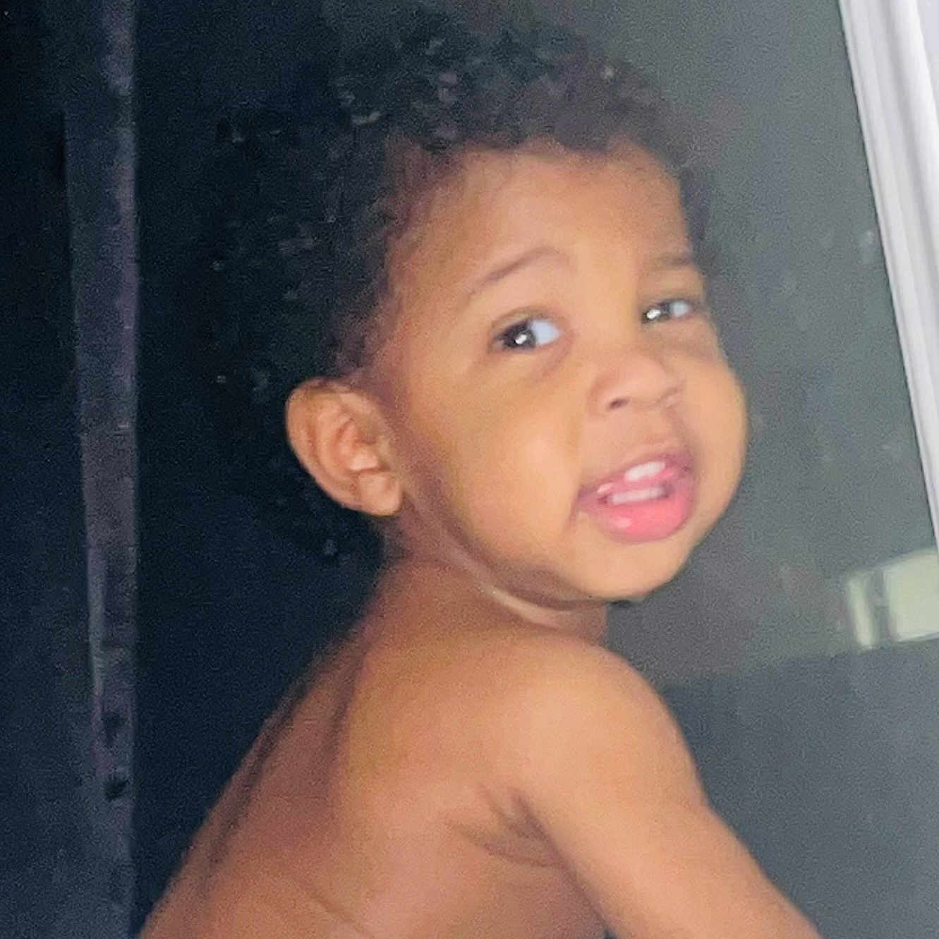 Austin joined the competition — help win amazing prizes! toddler, child, curly_hair, face, smiling, portrait, skin, bare_shoulders, indoor, person, young_child, expression, looking_back, cute, baby, head, eye, mouth, cheek, dark_background