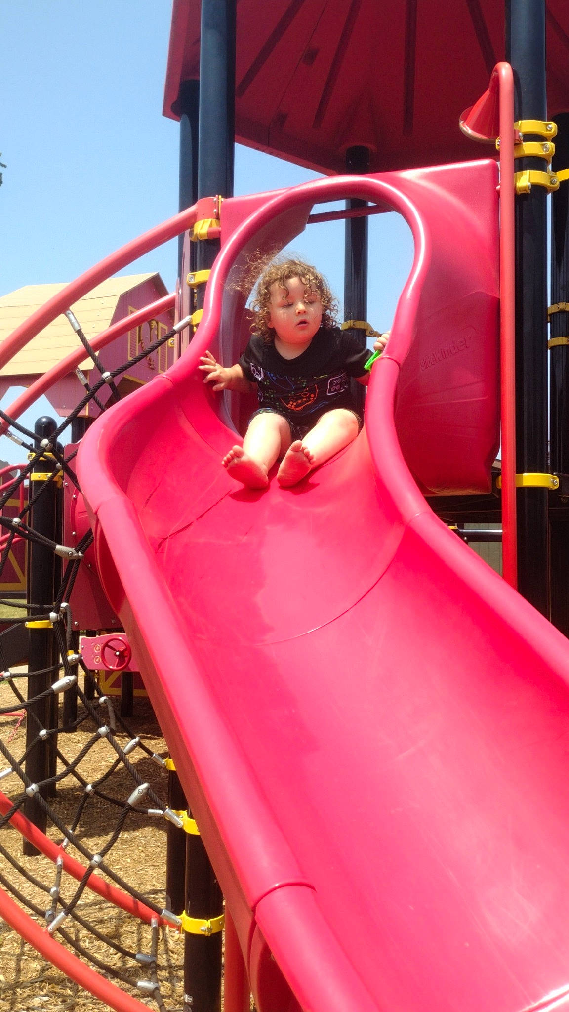 Caleb Charles is registered to the contest to win money with this photo: amusement_park, amusement_ride, automotive_exterior, chute, city, fun, leisure, magenta, motor_vehicle, nonbuilding_structure, outdoor_play_equipment, person, pink, play, playground, playground_slide, recreation, red, sky, smile