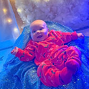 Bella-Rose is registered to the contest to win money with this photo: baby, blanket, blue, cherry_pattern, child, clothing, cozy, cute, face, happy, indoors, infant, pink_outfit, playful, portrait, relaxing, smiling, soft_lighting, sparkling, toddler