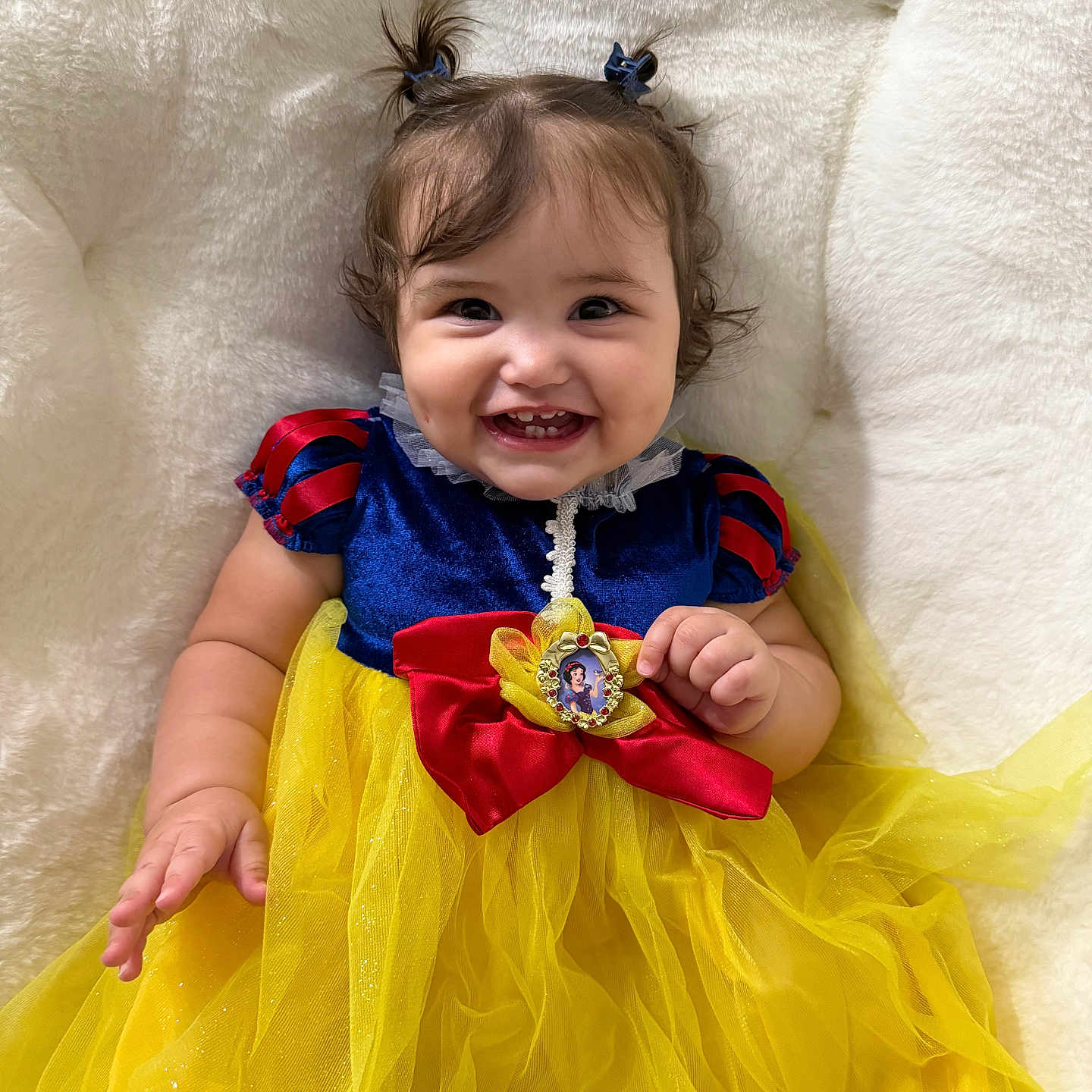 Sophia is registered to the contest to win money with this photo: accessories, baby, bodypart, clothing, couch, dress, face, finger, formalwear, furniture, hand, happy, head, jewelry, necklace, person, photography, portrait, sitting, smile