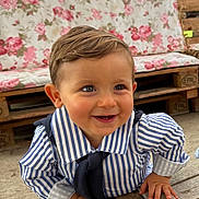 Malo participe au concours pour gagner de l'argent avec cette photo : baby, child, smile, striped_shirt, navy_tie, crawling, wooden_deck, face, blue_eyes, hair, furniture, couch, floral_pattern, outdoor, daylight, cute, happy, person, portrait, infant