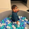 Saayan joined the competition — help win amazing prizes! toddler, child, ball_pit, balls, indoor, carpet, wall, door, curious, play, toy, colorful, blue, white, teal, person, young_child, hair, long_sleeve, expression