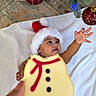 baby, child, santa_hat, cookie, snowman_cookie, christmas_tree, christmas_ornament, holiday, festive, reaching, blanket, indoor, decorations, hand, celebration, cute, smiling, face, holiday_season, christmas