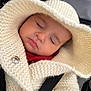 baby, sleeping, hood, knitwear, sweater, car_seat, strap, child, peaceful, soft, warm, face, closed_eyes, infant, cute, cozy, clothing, portrait, resting, indoors