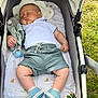 Martin participe au concours pour gagner de l'argent avec cette photo : baby, blanket, child, clothing, footwear, grass, head_support, infant, nature, outdoor, peaceful, person, polo_shirt, shoes, shorts, sleep, sleeping, soft_toy, stroller, toy