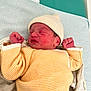 newborn, baby, infant, sleeping, hat, striped_clothing, yellow, white, knit_hat, fist, cozy, soft_texture, blanket, bed, cute, peaceful, indoors, portrait, child, resting