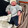 newborn, baby, sleeping, infant, hat, blanket, plush_toy, hand, clothing, hospital, nursery, bed, soft_toy, warm, cozy, resting, person, indoors, cute, child
