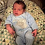 Mylo a rejoint le concours — aidez-le/la à gagner de superbes lots ! baby, newborn, infant, blue_onesie, dumbo_elephant, patterned_cushion, geometric_pattern, indoor, sleeping_bag, child, person, cute, cozy, soft_fabric, resting, small_hands, face, head, lying_down, home