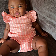 Jamyah joined the competition — help win amazing prizes! baby, child, girl, pigtails, pink_outfit, striped_clothing, couch, indoor, smiling, sitting, footwear, sandals, happy, cute, portrait, skin, furniture, infant, one_person, young_child