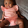 baby, child, girl, pigtails, pink_outfit, striped_clothing, couch, indoor, smiling, sitting, footwear, sandals, happy, cute, portrait, skin, furniture, infant, one_person, young_child