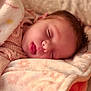 Lilith is registered to the contest to win money with this photo: baby, infant, newborn, sleeping, tongue_out, blanket, bedding, soft_texture, cozy, closeup, face, peaceful, pajamas, portrait, head, adorable, cute, indoors, resting, skin